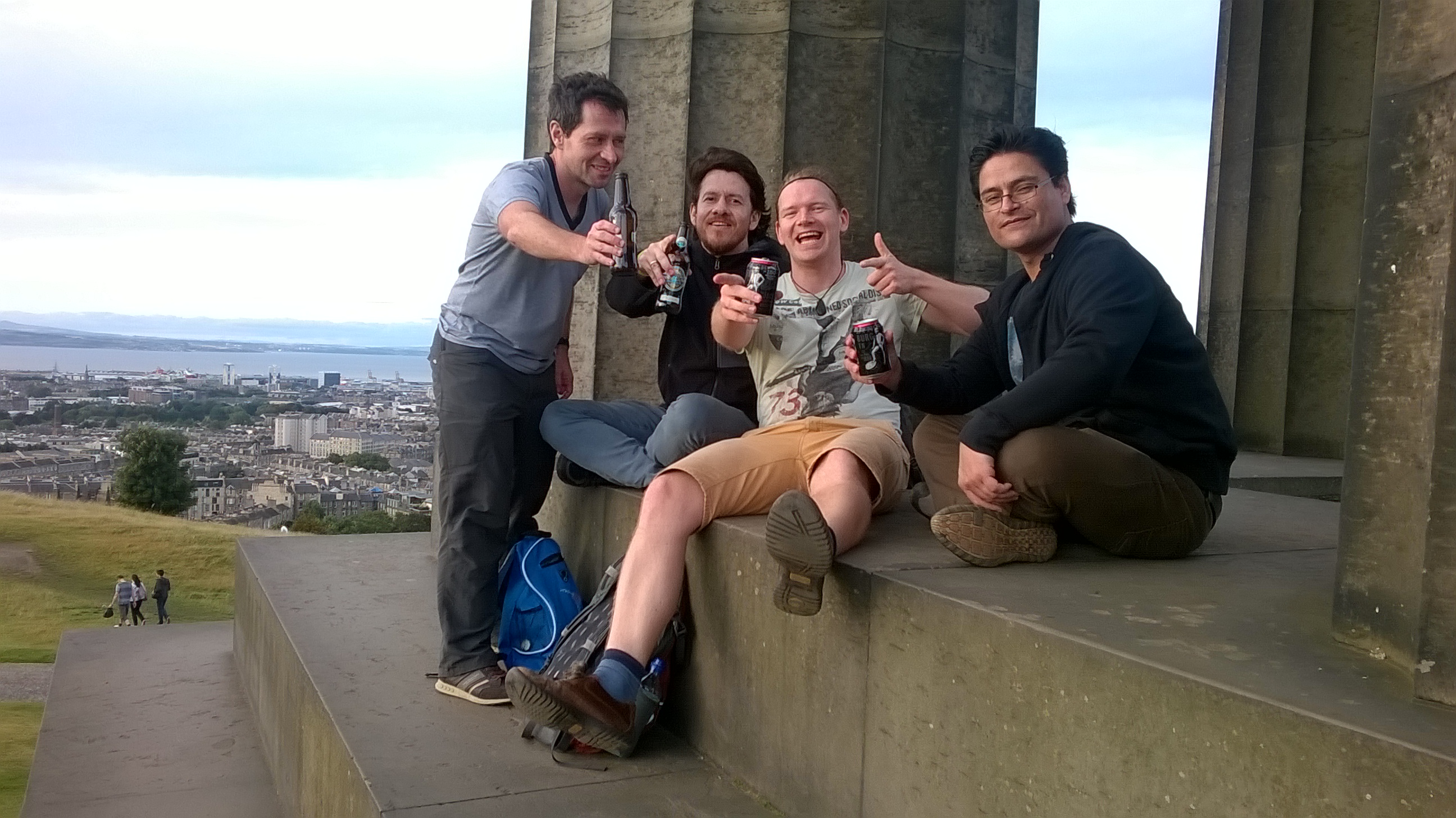 three male persons sitting in a pavillon